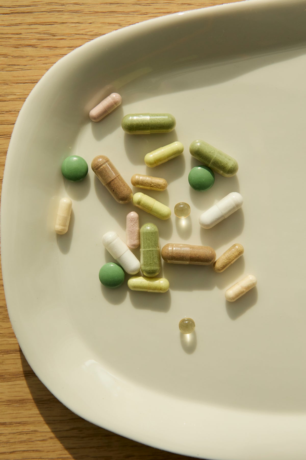 Pills and supplements on a white ceramic plate